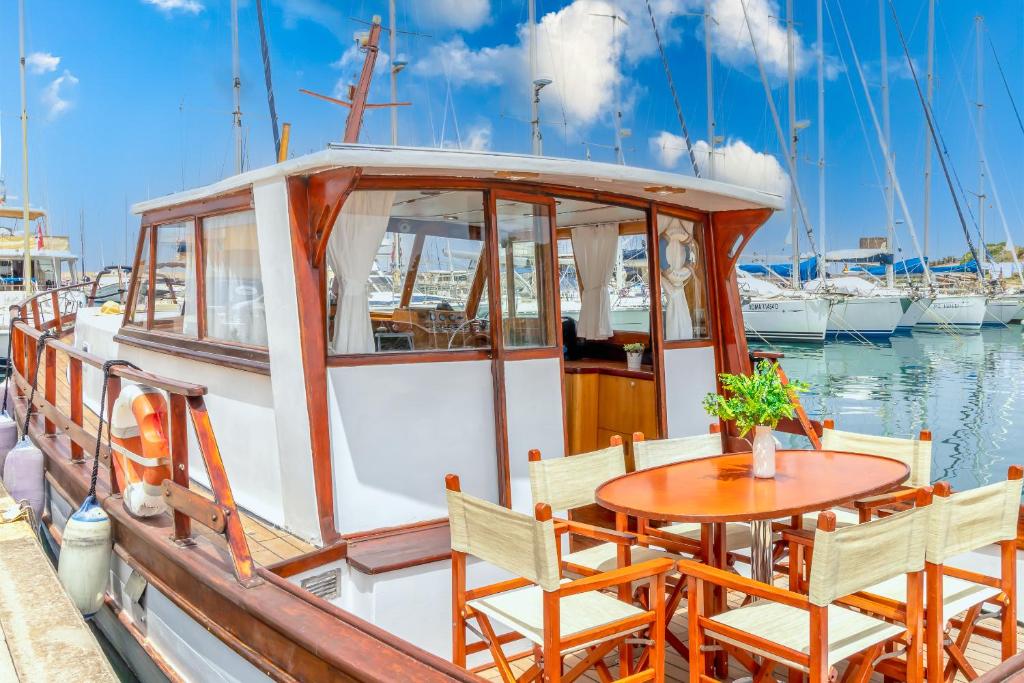 a table and chairs on a boat in the water at Marta Boat B&B in Castelsardo