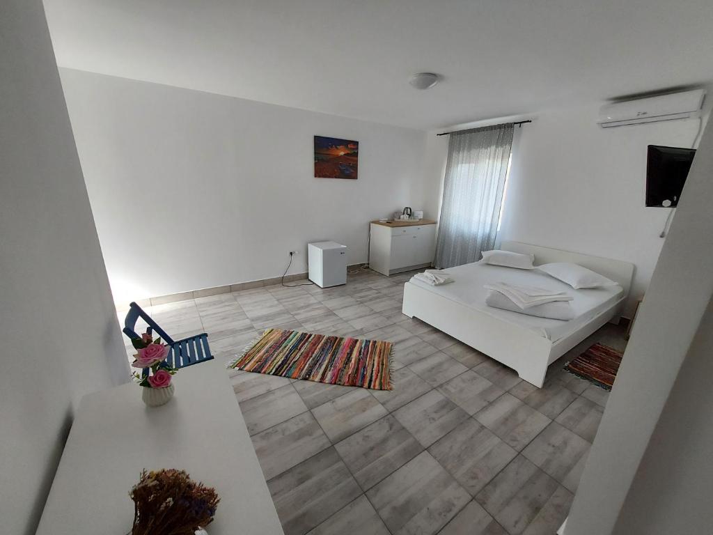 Sala de estar blanca con cama y mesa en Casa Dada en Două Mai