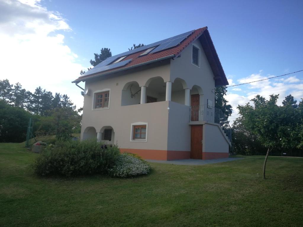 a white house with a red roof at Bottyahát guesthouse in Rezi