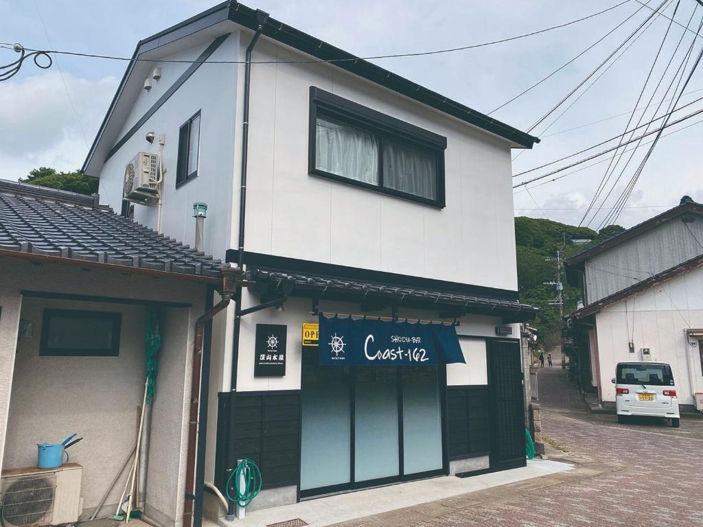 a white building with a sign on the side of it at Watatsumi no yado - Vacation STAY 44120v in Iki
