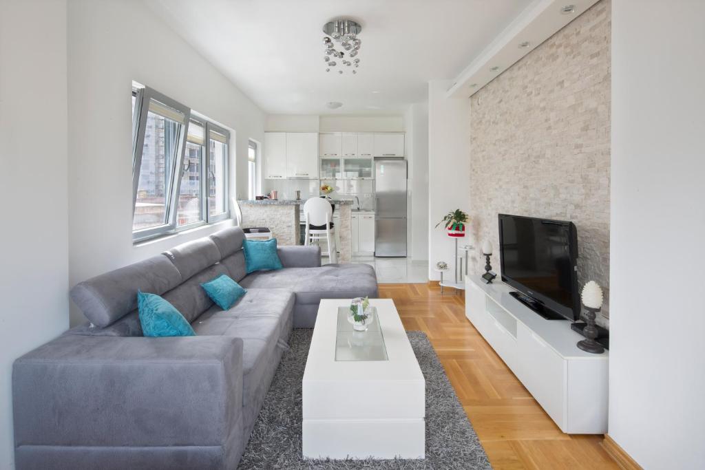 ein Wohnzimmer mit einem Sofa und einem TV in der Unterkunft City center lux apartment in Budva