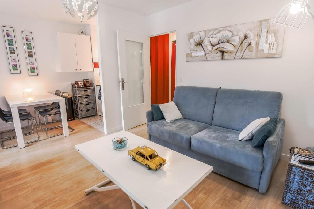 a living room with a blue couch and a table at Studio Faidherbe - Welkeys in Les Lilas
