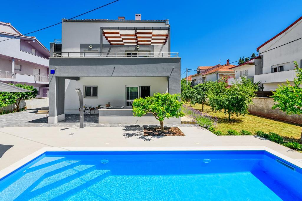 Villa con piscina frente a una casa en Apartman Anđelka, en Zadar