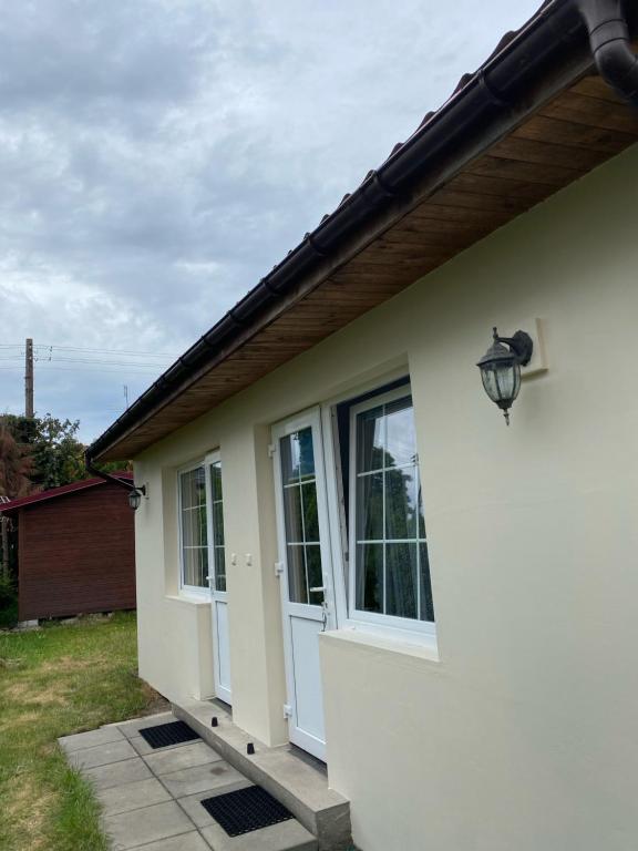 a white house with a door and windows at Pokoje goscinne Miedzywodzie in Międzywodzie