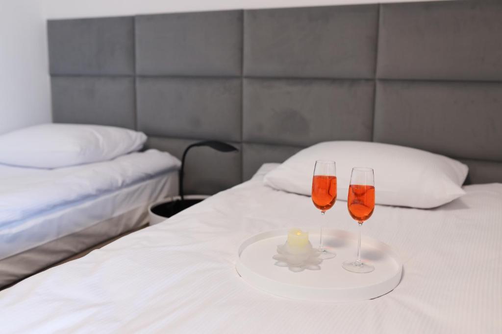 dos copas de vino en una cama con una vela en WILLA ILONA 1, en Łeba
