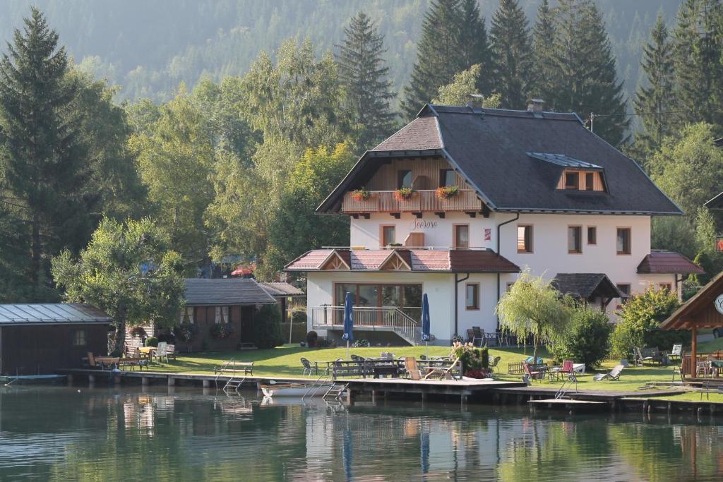 a house on the shore of a lake at Frühstückspension Seerose in Weissensee