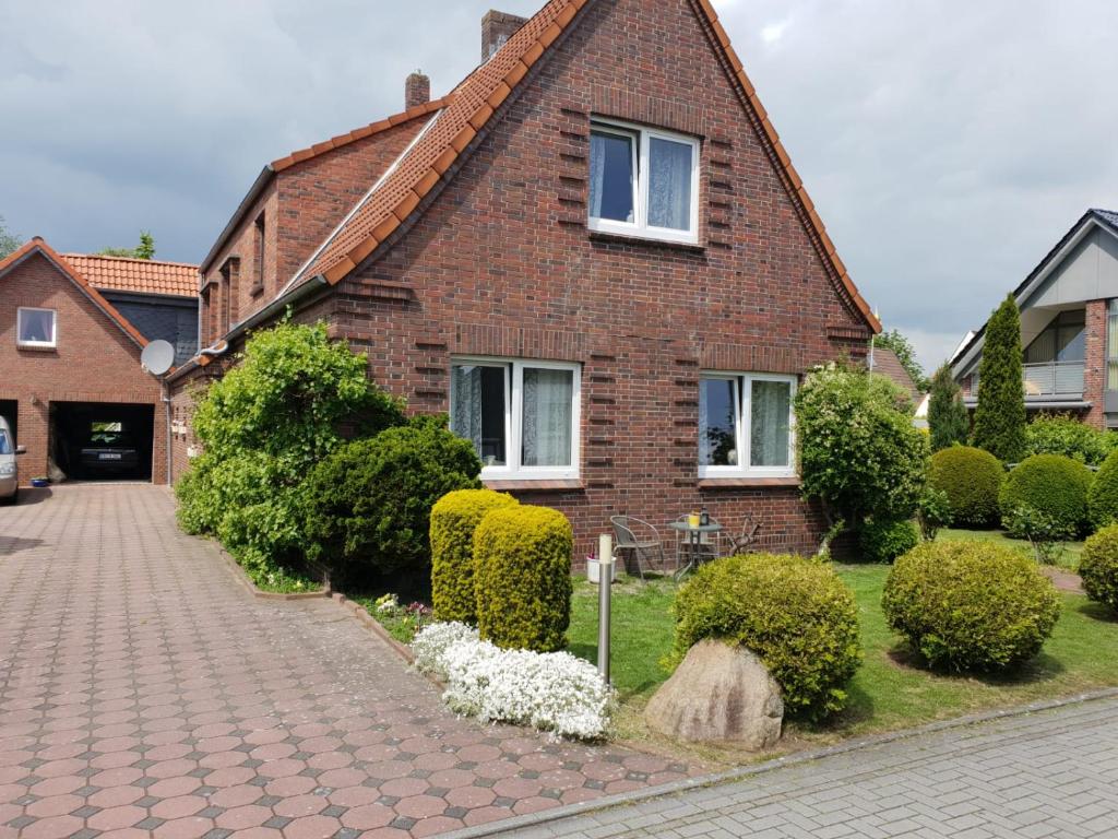 a brick house with a brick driveway in front of it at Stadtrand Wilhelmshaven in Schortens