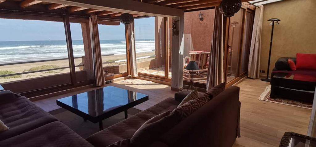 - un salon avec un canapé et une vue sur l'océan dans l'établissement Frikrik maison au bord de mer, à Aglou