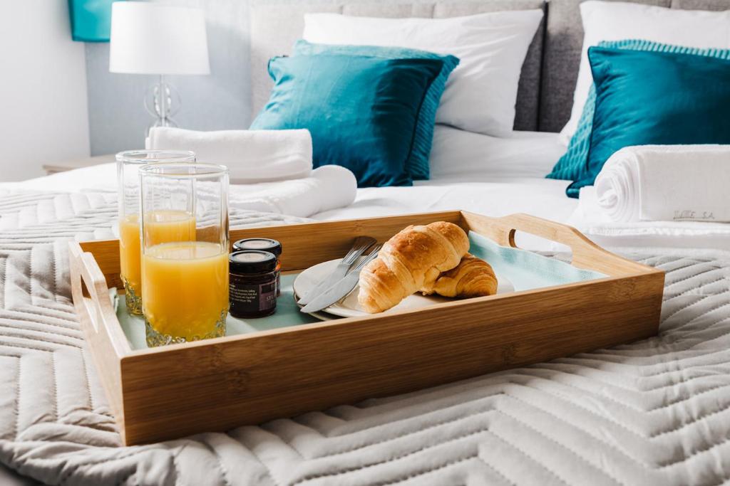 a tray of bread and orange juice on a bed at Seaforth House Apartment in Elgin