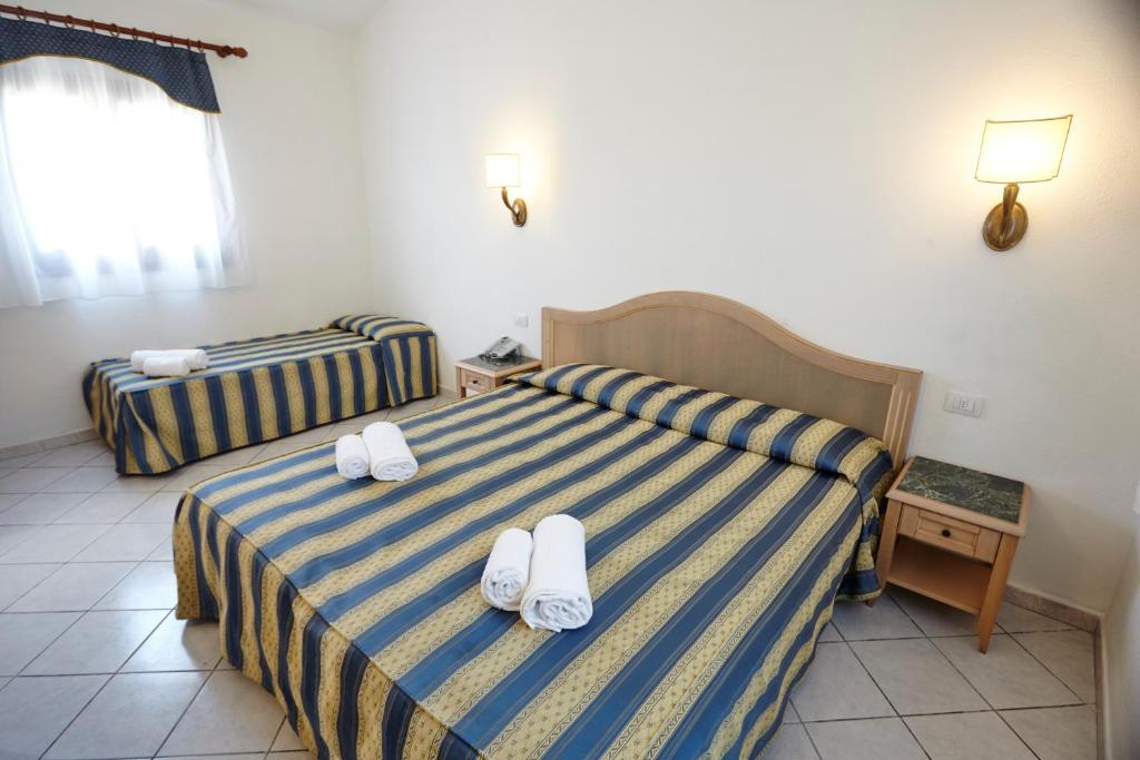 Postel nebo postele na pokoji v ubytování Hotel Cala Mirto