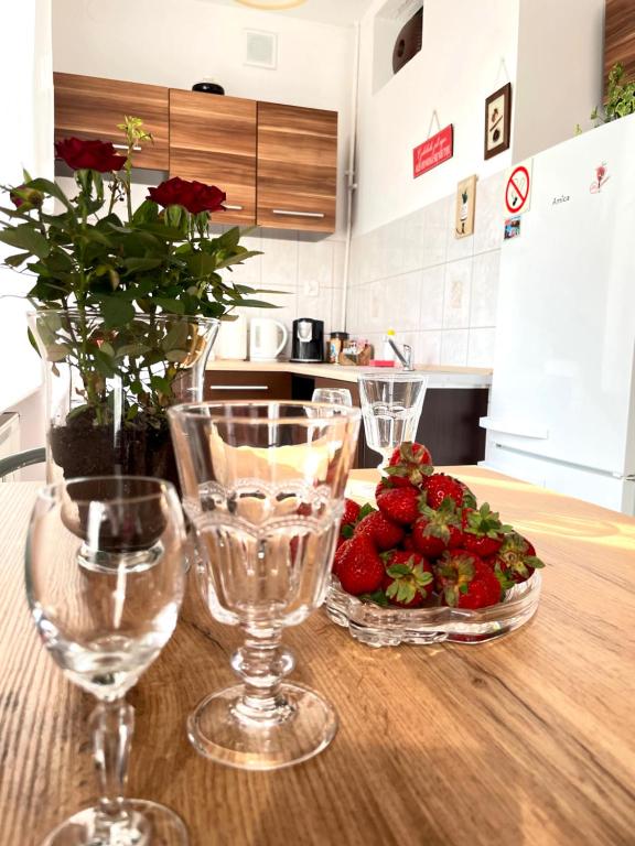 two wine glasses and a plate of strawberries on a table at STARE MIASTO in Olsztyn