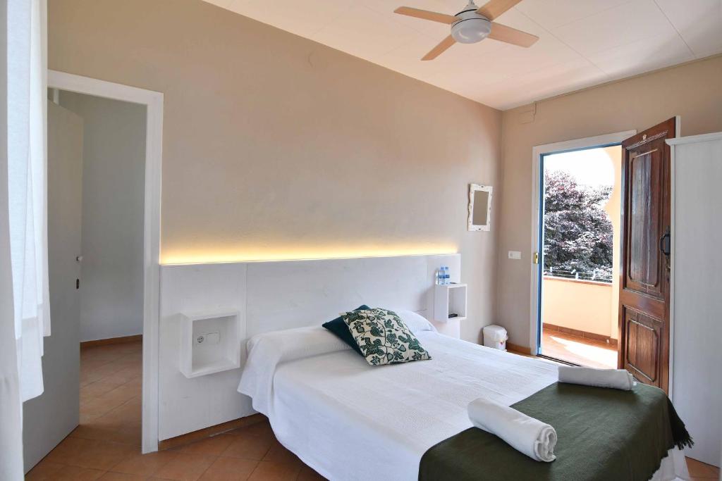 1 dormitorio con 1 cama y ventilador de techo en Hostal l'Estrella, en Palafrugell