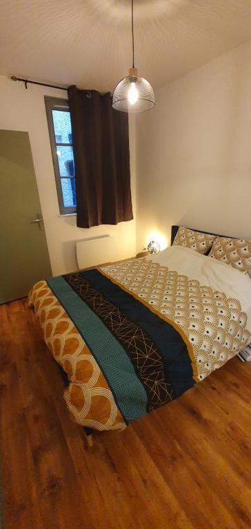 1 dormitorio con 1 cama en una habitación con ventana en Les balcons de Dieppe - appartement 1ER étage - certifié 3 étoiles au cœur de la rue piétonne en Dieppe