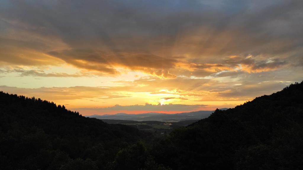 um pôr do sol nas montanhas com o pôr do sol em Chata Na Przełęczy em Poręba