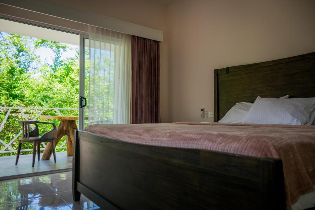 1 dormitorio con 1 cama y puerta corredera de cristal en Casa Coco de Mer 1 en Tamarindo