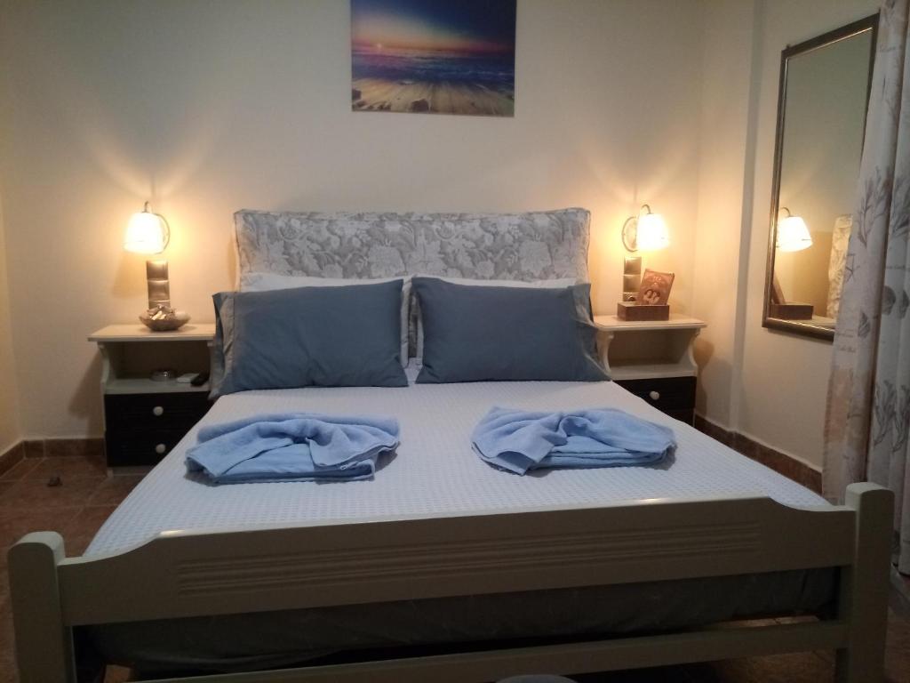 a bedroom with a bed with blue towels on it at Studios Eftichia in Fournoi