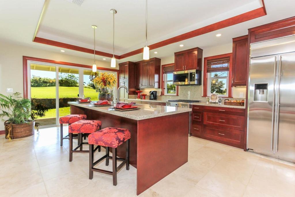 a kitchen with a large island with bar stools at Pili Aloha in Koloa