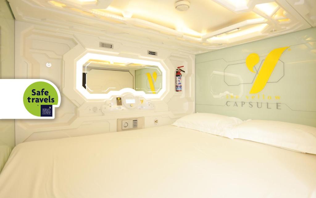 a bedroom with a white bed and a mirror at The Yellow Capsule Experience in Cancún