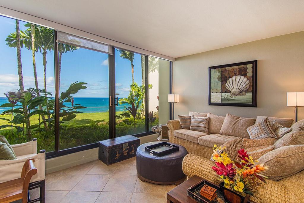 a living room with a couch and a view of the ocean at Puu Poa in Princeville