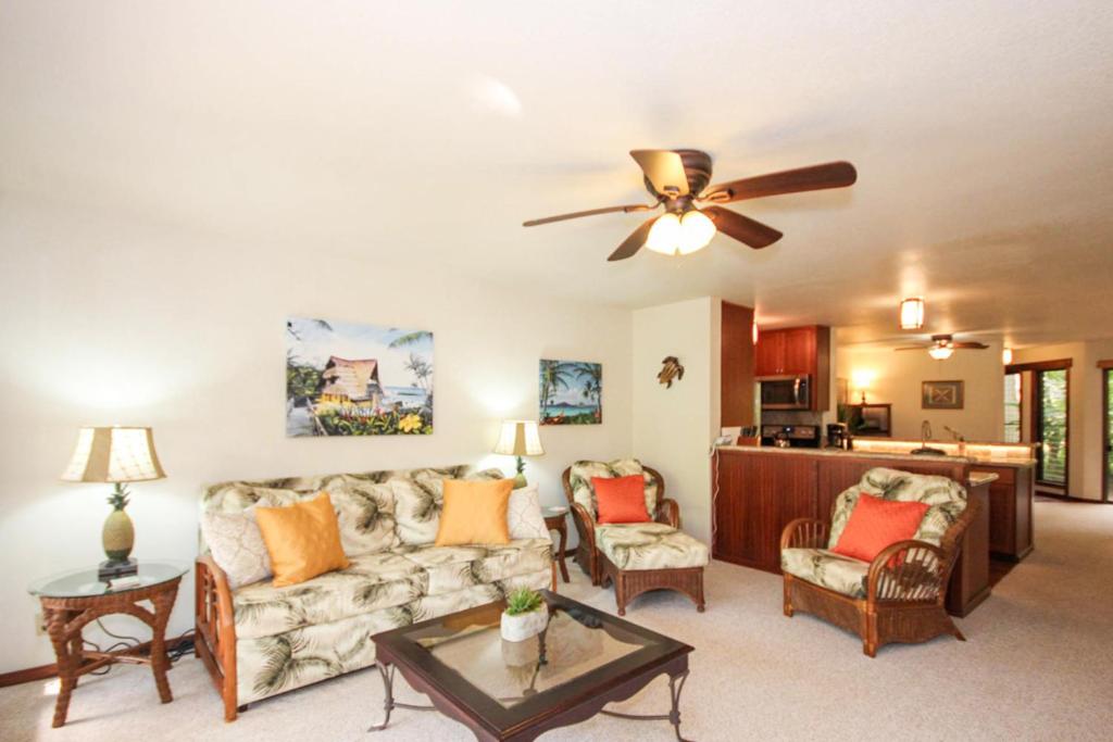 a living room with a couch and a ceiling fan at Waikomo Streams 202 in Kipu