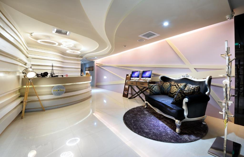 a lobby with a chair and a desk with two computers at NL Concept Hotel in Kaohsiung