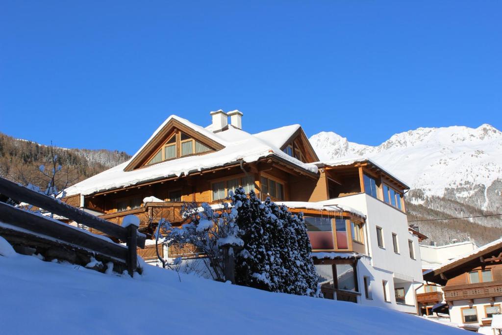 een huis in de sneeuw met bergen op de achtergrond bij Appartement Kalkus-Sölden in Sölden