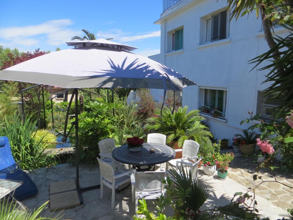 un patio con mesa y sombrilla en Villa Ingrid, en Saint-Tropez