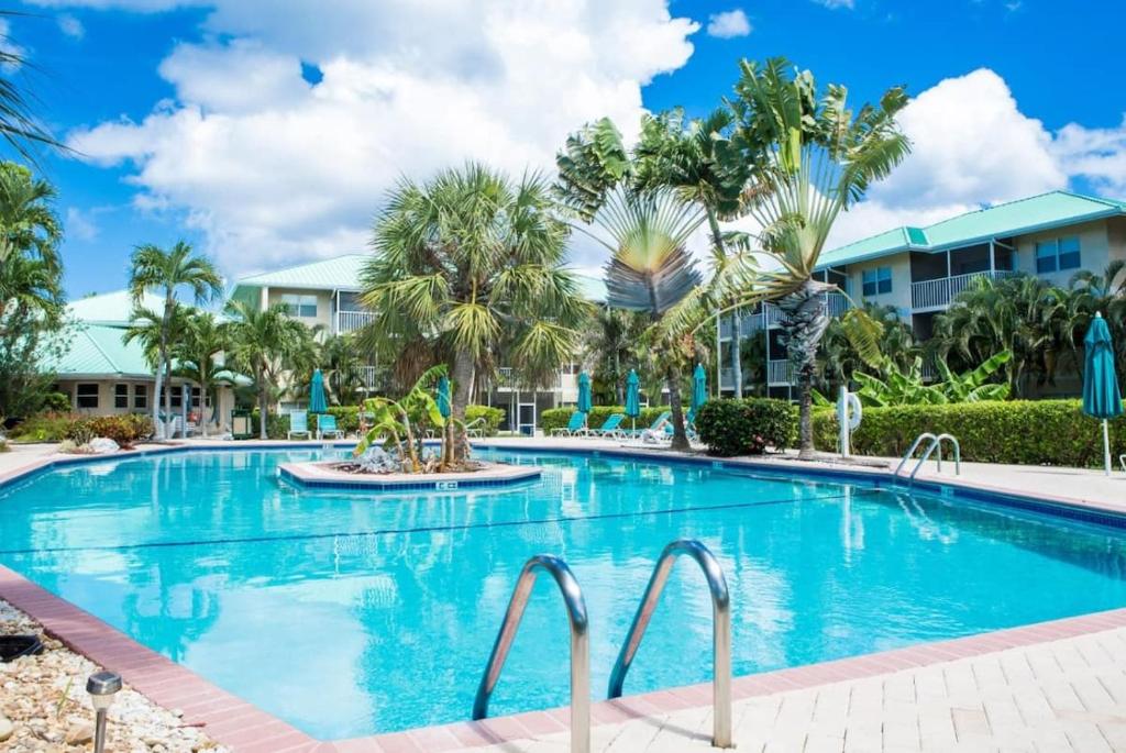 - une piscine dans un complexe avec des palmiers dans l'établissement Beach Living at Plantation Village BLGS, à George Town