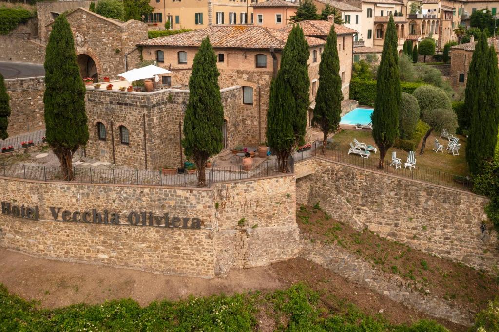 - une vue aérienne sur un bâtiment avec des arbres et une piscine dans l'établissement Hotel Vecchia Oliviera, à Montalcino