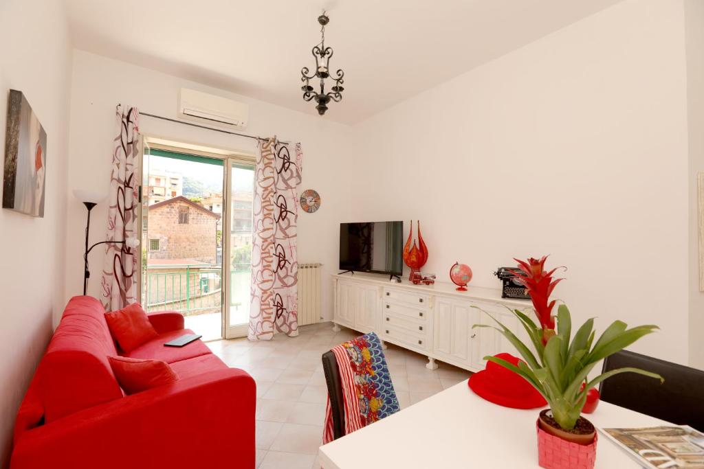 sala de estar con sofá rojo y TV en Estate4home - Casa Pina, en Sorrento