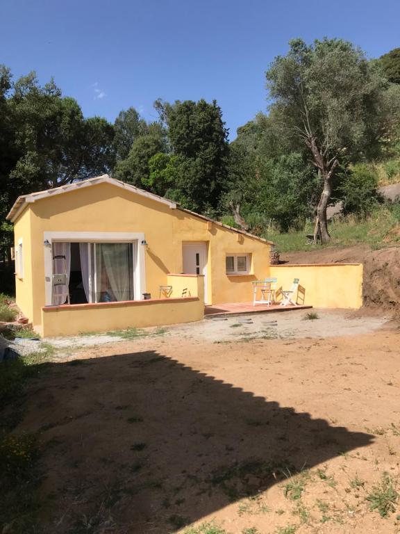 una pequeña casa amarilla en medio de un campo en Domaine Trevinella, en Cauro
