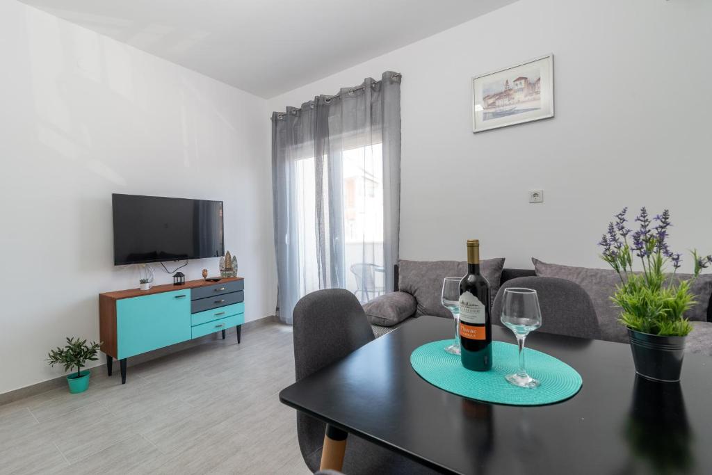 uma sala de estar com uma mesa e um copo de vinho em Apartmani Ante & Šime em Trogir