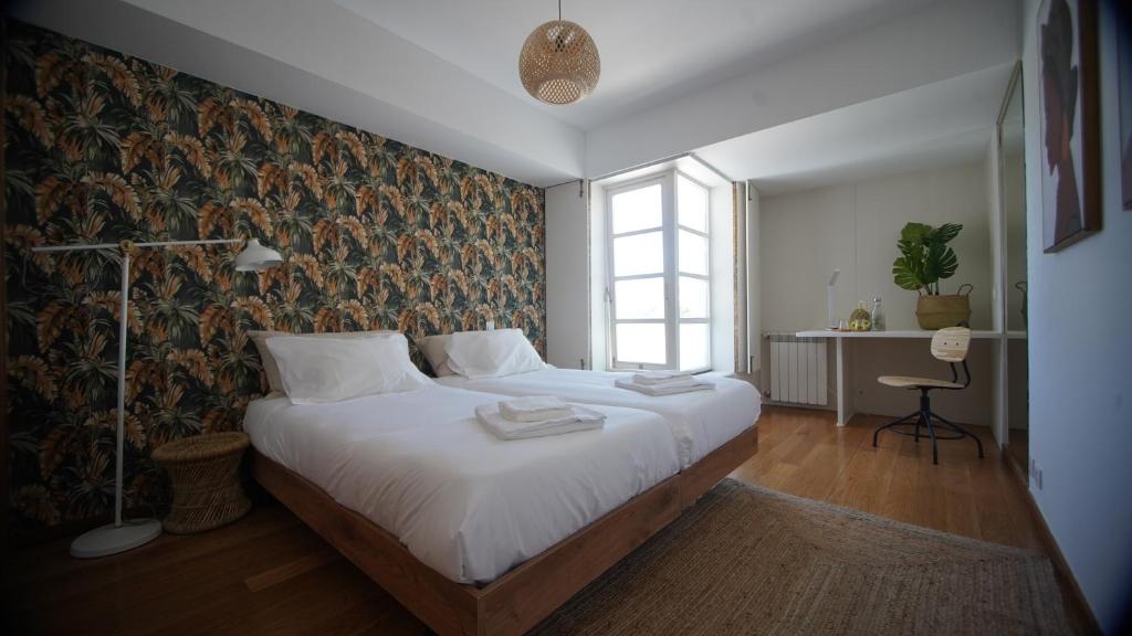 sypialnia z dużym łóżkiem i oknem w obiekcie Sea Soul Esposende w mieście Esposende