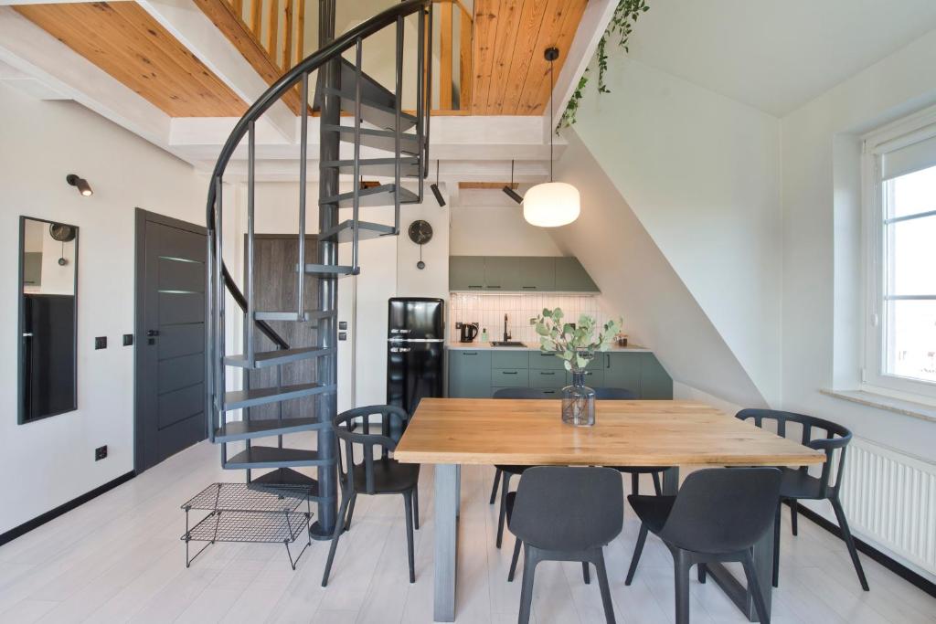 cocina y comedor con mesa de madera y sillas en Apartamenty Zacisze, en Gdansk