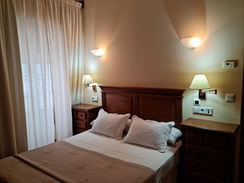 1 dormitorio con 1 cama con 2 almohadas blancas en Hotel Plateros, en Córdoba