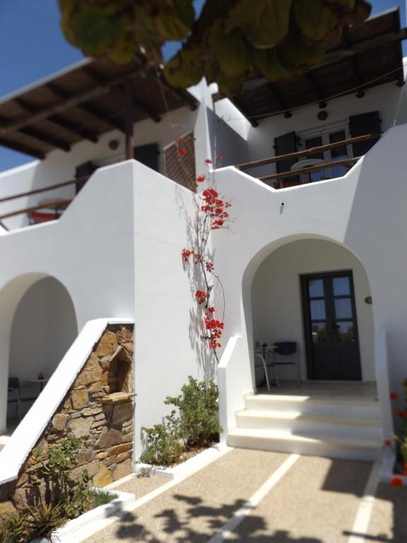 a white house with white walls and stairs at Venus Rooms in Manganari