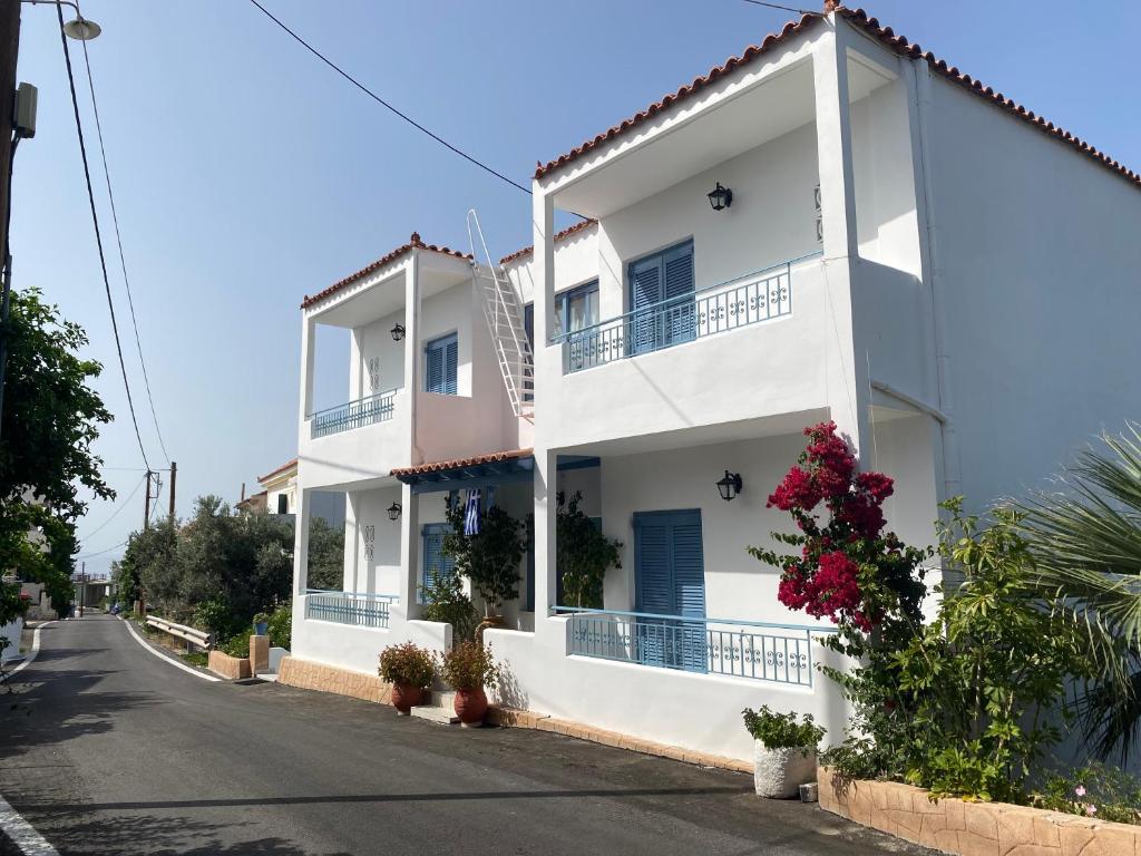 una casa blanca con flores en una calle en Studio Mare, en Megalochori