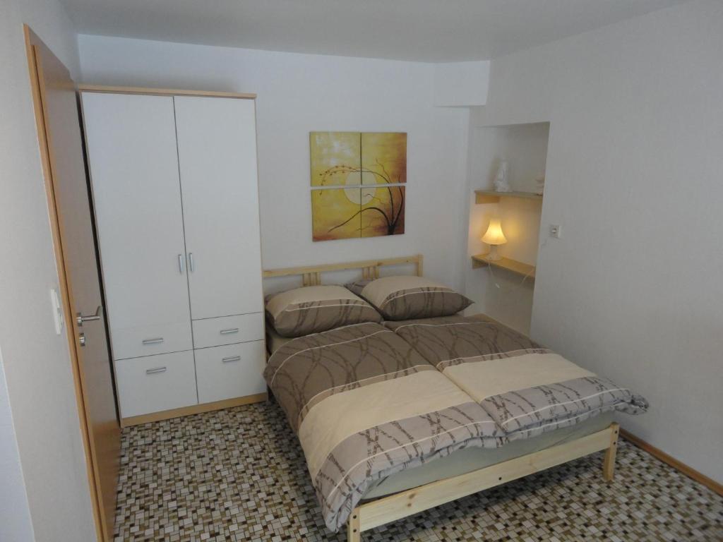 1 dormitorio con 1 cama y armario blanco en Haus Wangen Studio en Burg-Reuland	