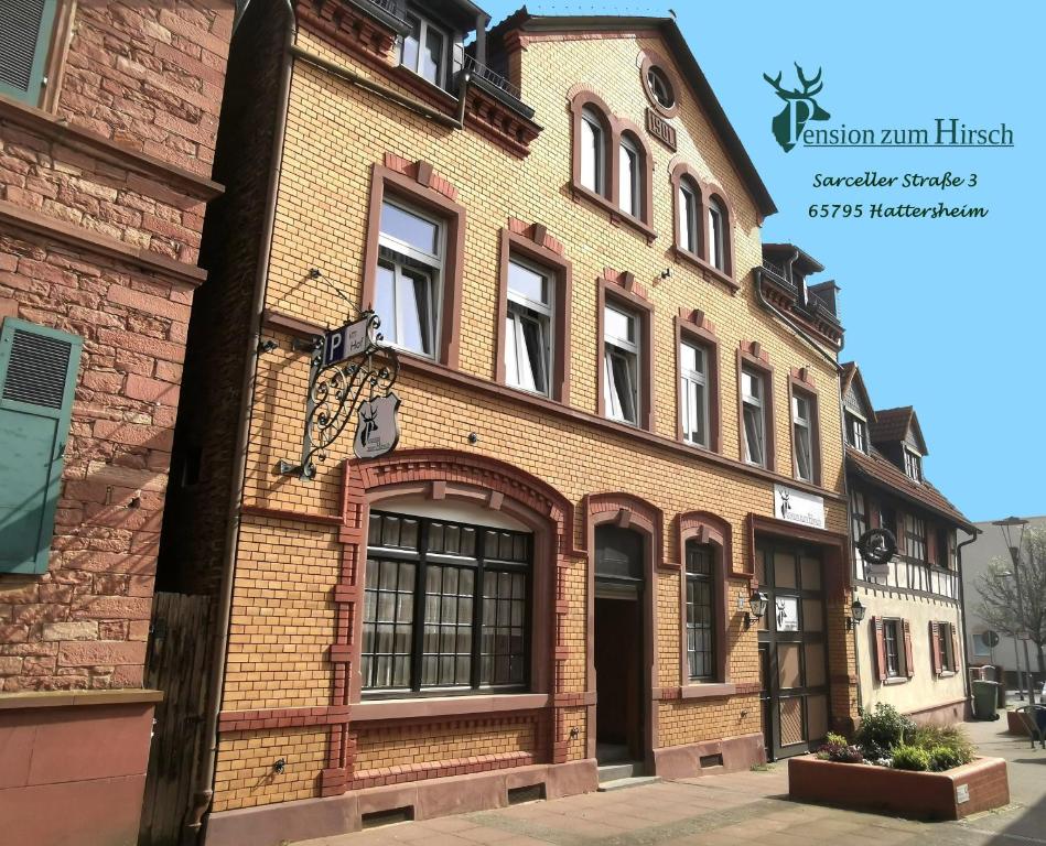 an old brick building on the corner of a street at Pension zum Hirsch in Hattersheim