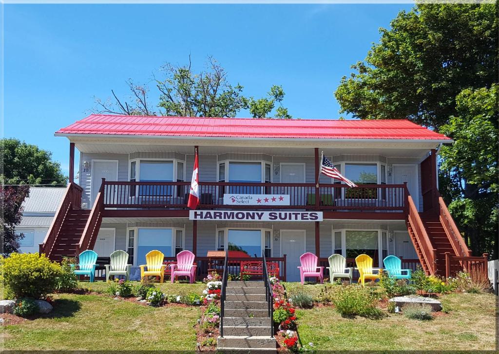 a house with chairs and a sign that reads happyipop suites at Harmony B&B and Suites in Digby