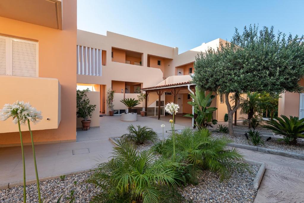 a courtyard of a building with trees and plants at Cirillo Family Hotel-Christinas Studios in Mastihari