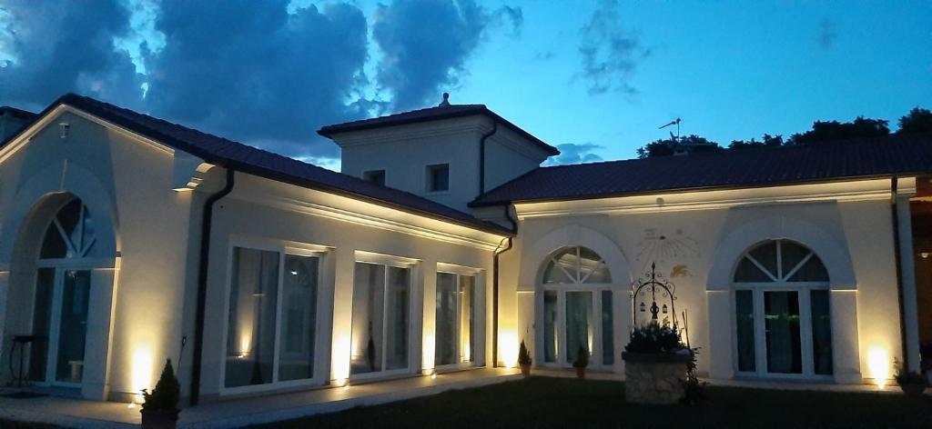 a large white house with lights on it at night at B&B Borgo Arcadia in Poiana Maggiore