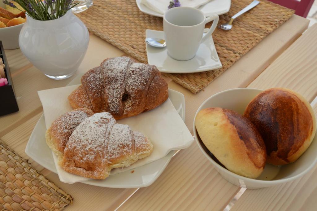 a table with two plates of pastries and a cup of coffee at B&B Fermata 106 da Carolina in Siculiana Marina