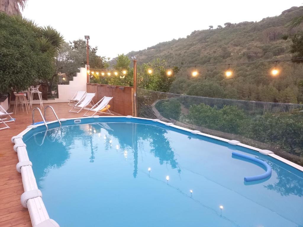 een groot zwembad met een berg op de achtergrond bij AgriTrinacria Rooms in Piazza Armerina