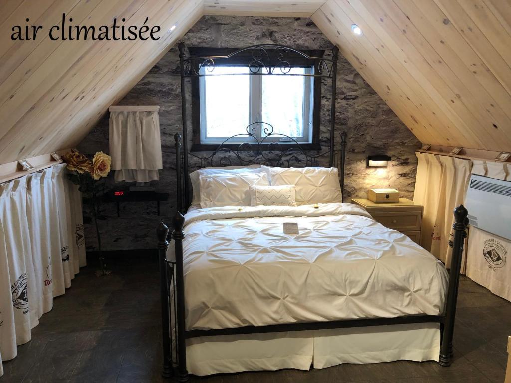 a bedroom with a bed and a dresser at Appartement champêtre in Saguenay