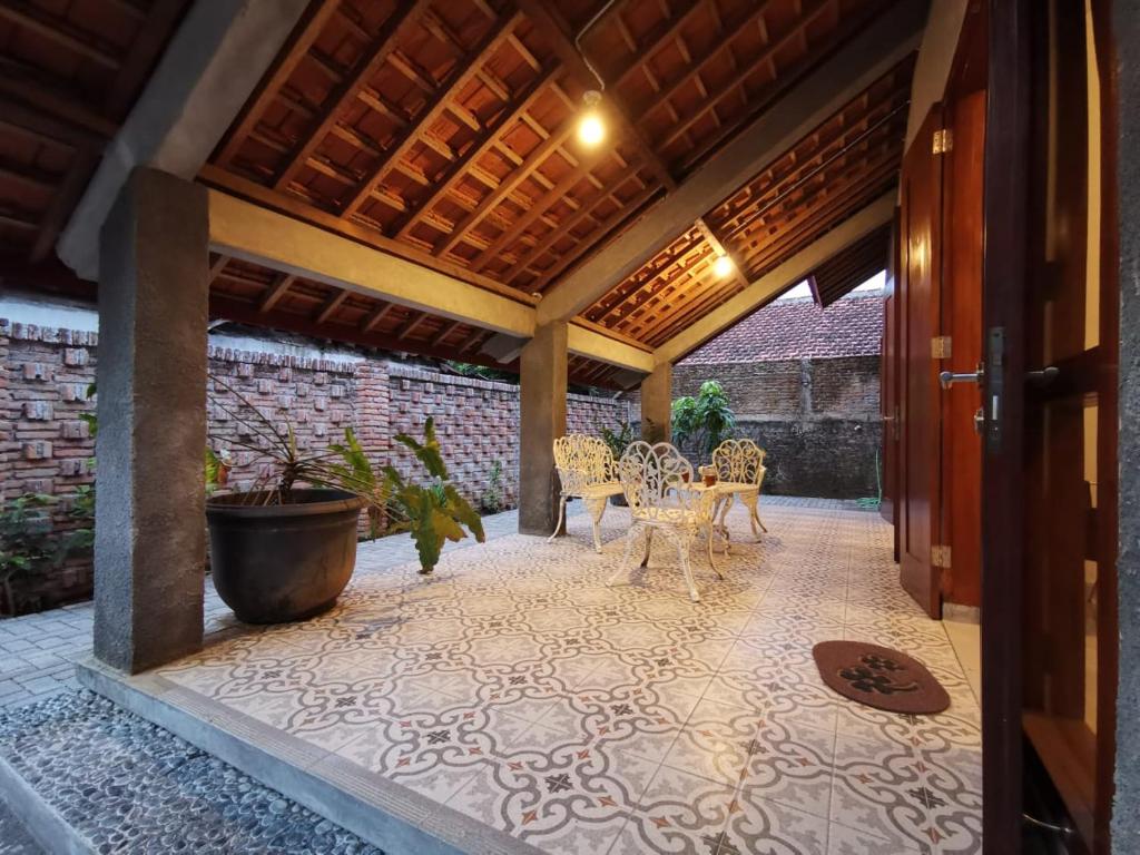 a patio with a table and chairs on it at Mawartiga Homestay in Demangan