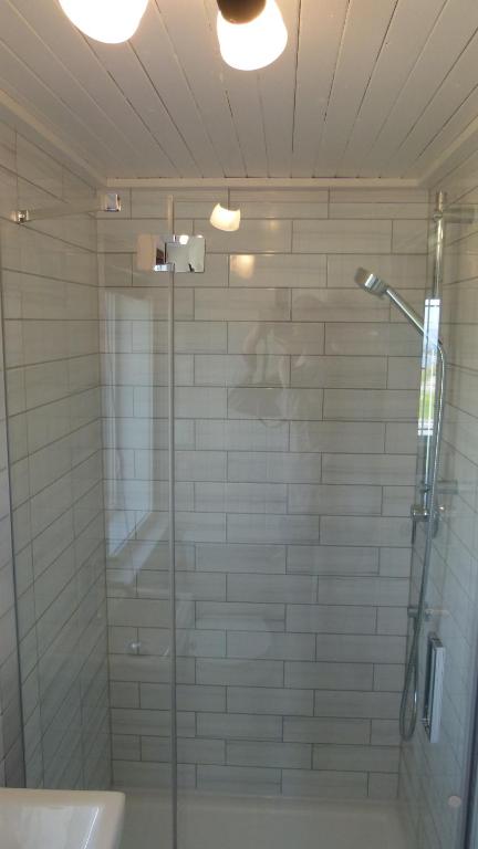 a shower with a glass door in a bathroom at La Maison entre Mer Montagnes in Cap-Chat