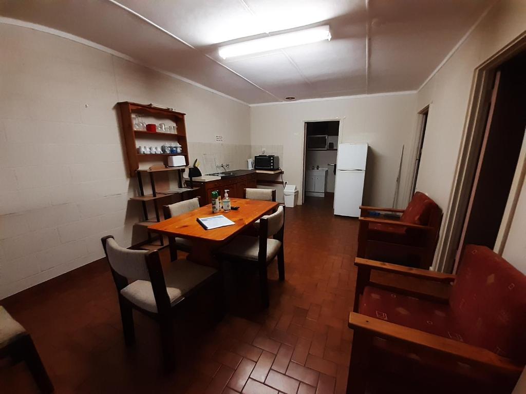 a room with a table and chairs and a kitchen at Pelican Point Waterfront Resort formerly Carnarvon Beach Retreat in Carnarvon