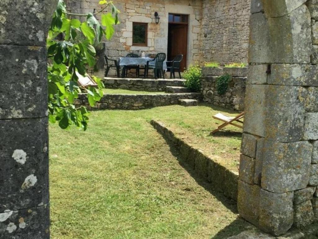 ein Steingebäude mit einem Tisch und Stühlen im Hof in der Unterkunft Gîte Borrèze, 4 pièces, 6 personnes - FR-1-616-152 in Borrèze