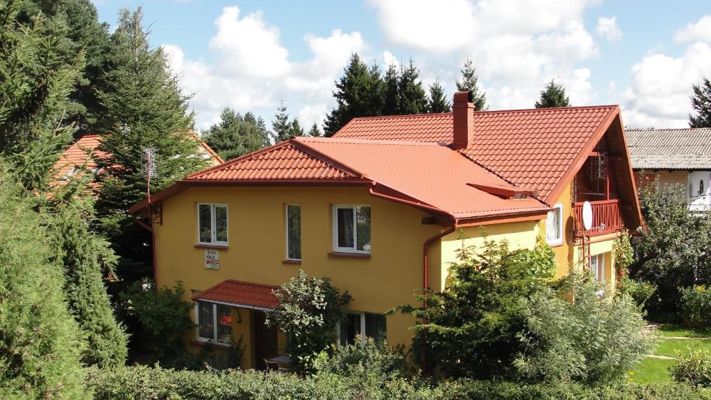 a yellow house with an orange roof at Blizniak nad Morzem in Rowy